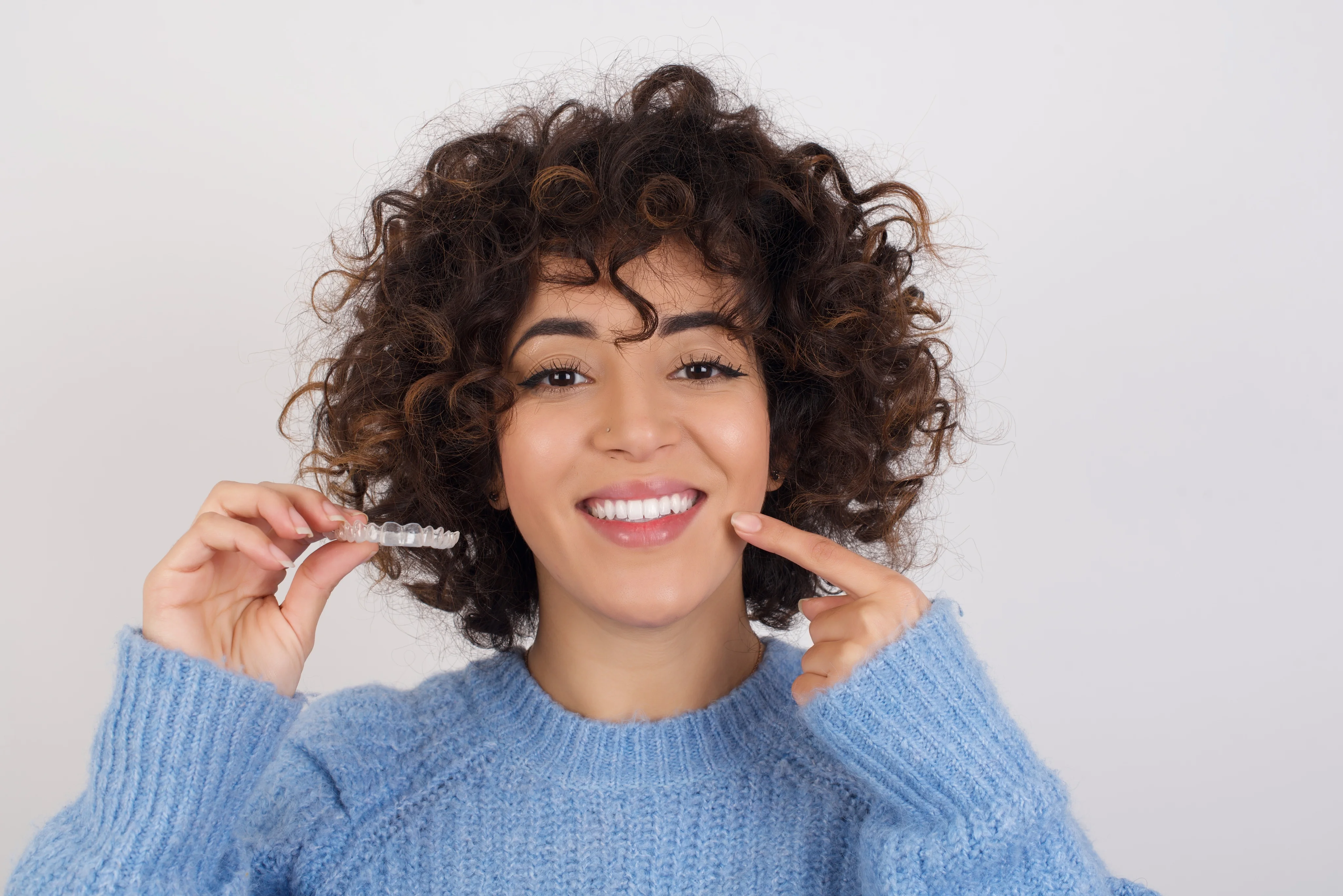 Young woman smiling with Invisalign aligners